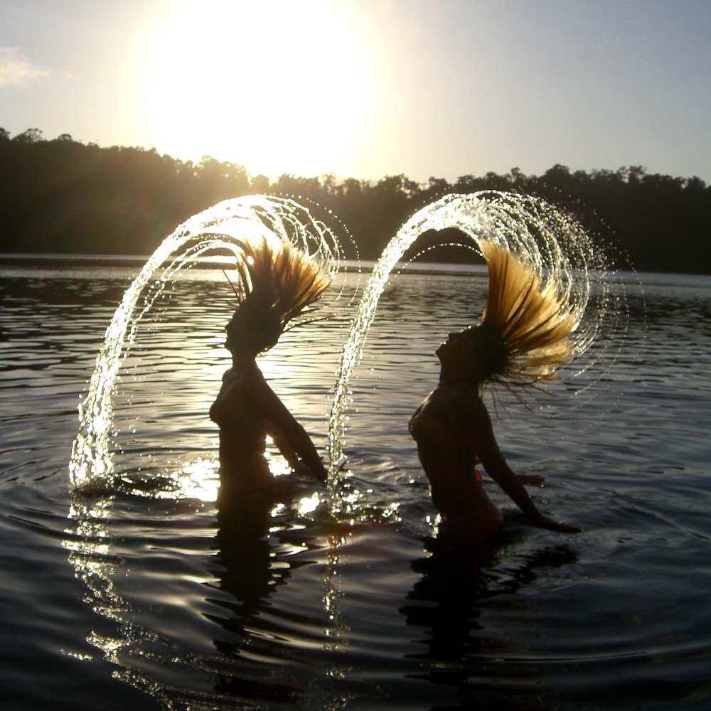 Girls flicking their hair at Lake Eacham onAtherton Tablelands Waterfalls