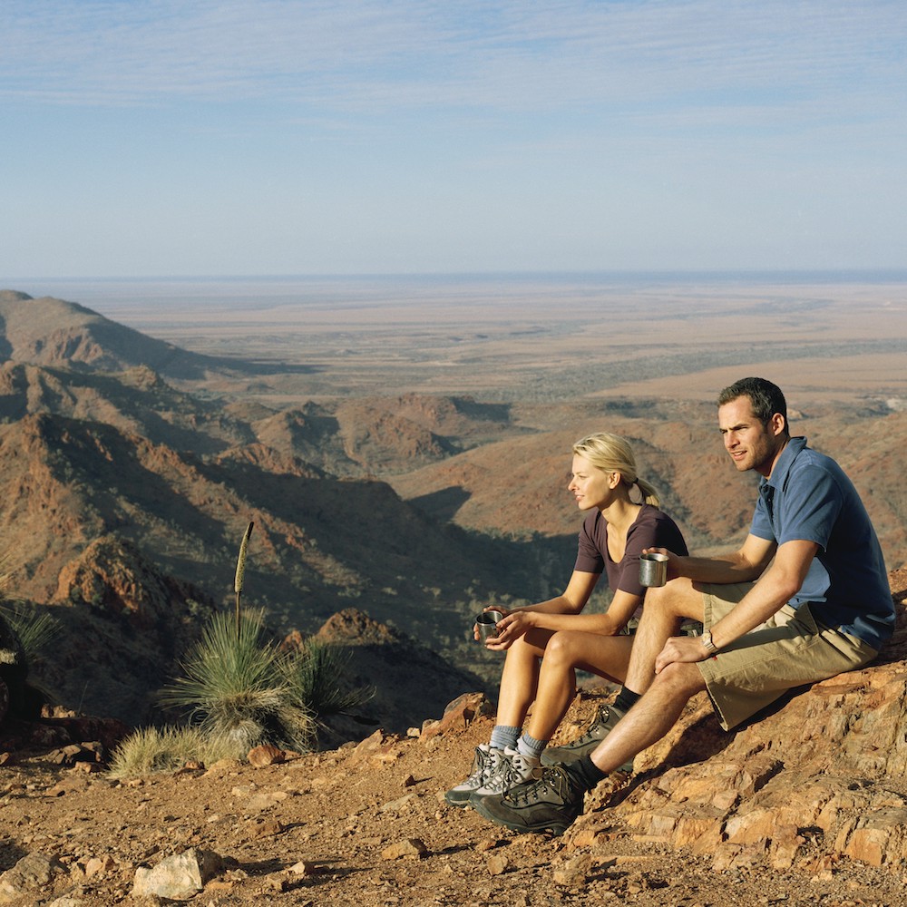 Couple sitting on a rock. The view from Sillers Lookout on our Flinders Ranges tours.
