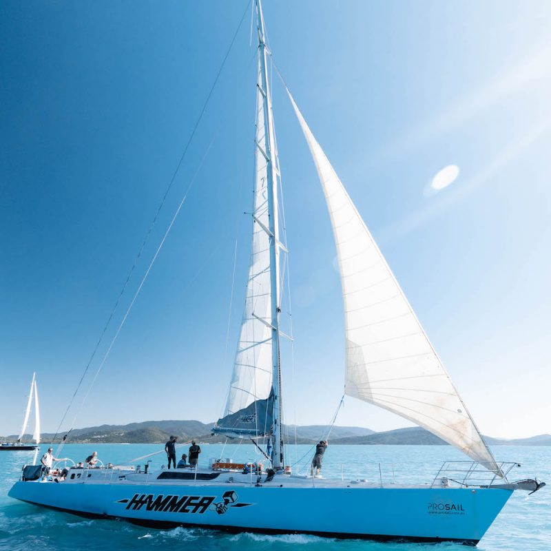 Hammer" sailing boat on crystal clear waters with a view of lush green islands, part of Real Aussie Adventures in Whitsunday Islands, Queensland.