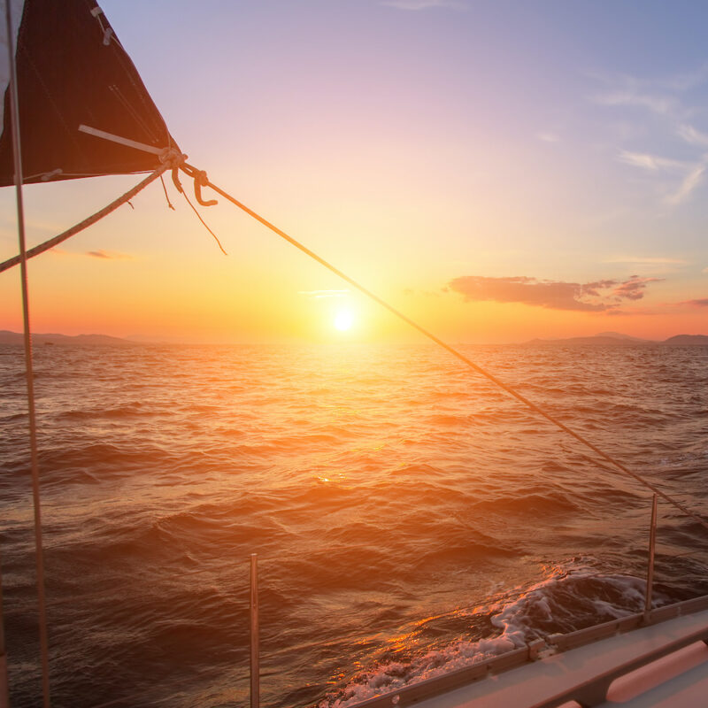 Beautiful sunset in the open sea with sailing yacht.