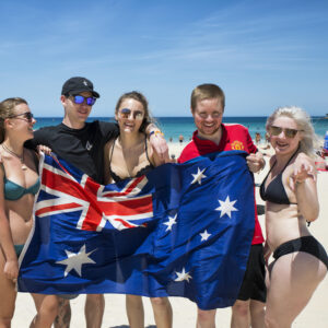 Welcome Week in Sydney. Group with the Australian flag on the beach.