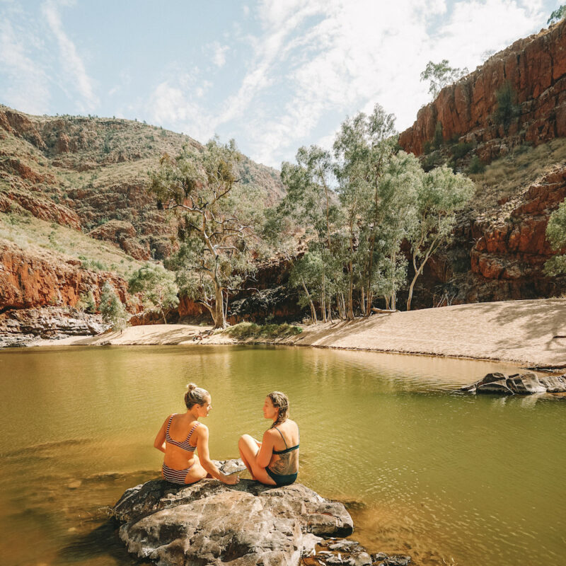 Real Aussie Adventures, Small Group Adventure Tours Australia. Two ladies on a rock. Swimming at Ormiston Gorge. Red Centre tours, Australia.