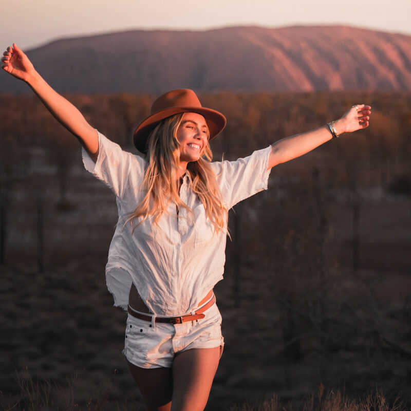 Real Aussie Adventures, Small Group Adventure Tours Australia. Woman at Uluru at sunset Red Centre tours, Australia.