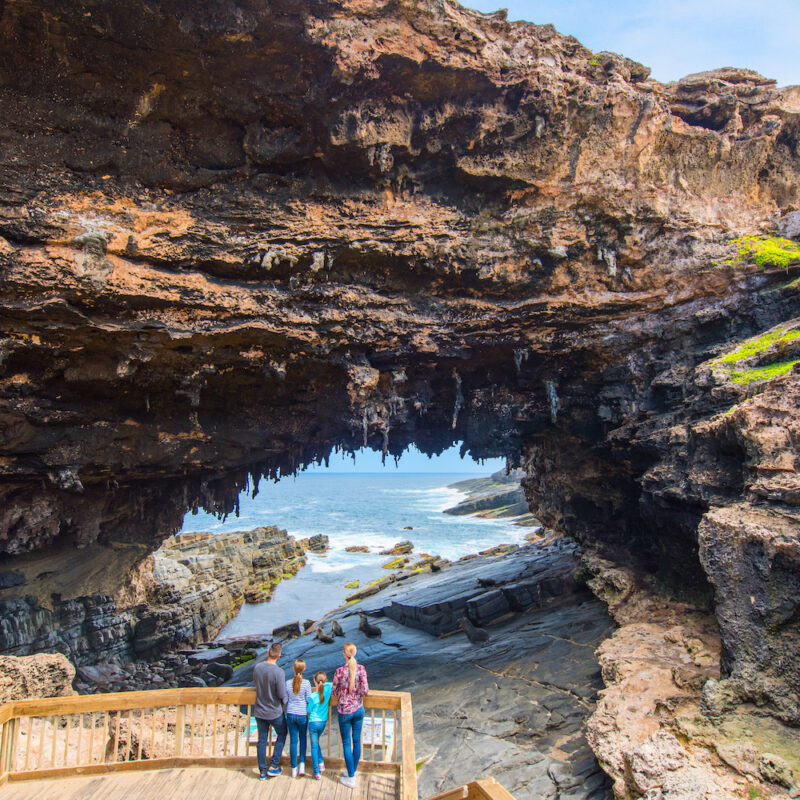 A Family at Admirals Arch on Kangaroo Island looking out to sea. Kangaroo Island tours.