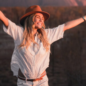 Real Aussie Adventures, Small Group Adventure Tours Australia. Woman at Uluru at sunset Red Centre tours, Australia.