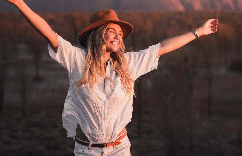 Real Aussie Adventures, Small Group Adventure Tours Australia. Woman at Uluru at sunset Red Centre tours, Australia.