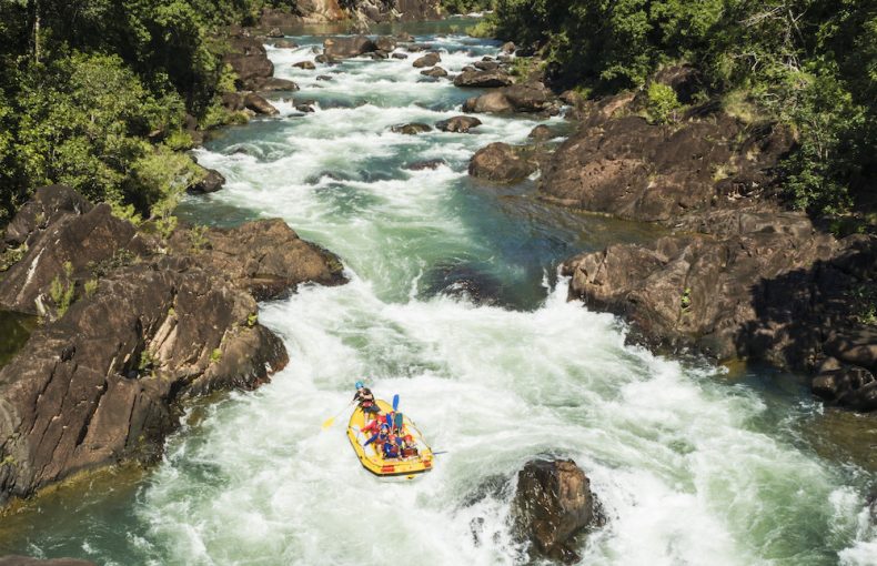 Aerial view of white water rafters tackling rapids in the rainforest surrounds of the Tully Gorge