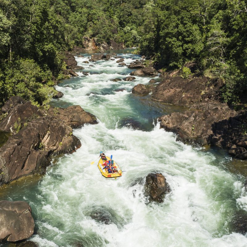 Aerial view of white water rafters tackling rapids in the rainforest surrounds of the Tully Gorge