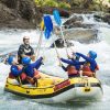 White water rafters cheer with their river guide after they complete another set of rapids on the Tully River
